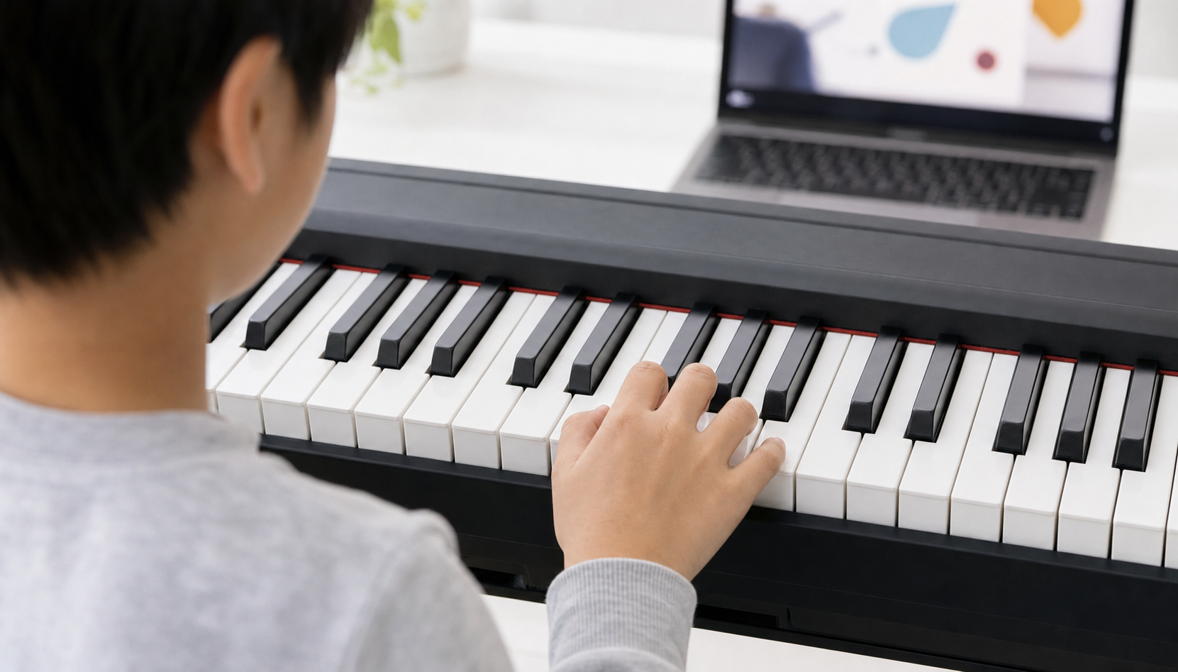 Child repeating one short piano pattern during an online video lesson on a correctly arranged keyboard